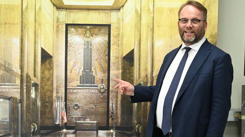 Lahn-Marmor ist auch im Empire-State-Building in New York verbaut. Minister Gremmels steht vor einem Bild des Empire State Buildings