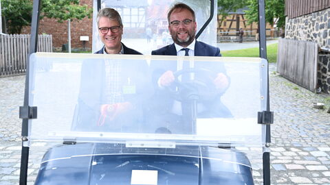 Durch den Hessenpark ging es im Minister-Mobil. Minister Gremmels in einem kleinen Mobil, mit dem er im Hessenpark herumfährt