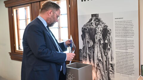 Minister Gremmels probiert eine Mitmachstation aus.