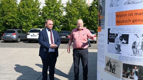 Minister Gremmels schaut sich eine Litfaßsäule zum Thema Demokratie an