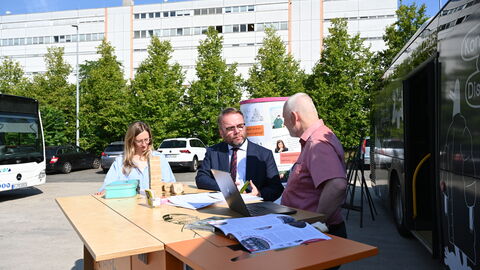 Demokratie erleben geht auch draußen. Minister Gremmels schaut sich das Angebot des DemokratieWagens an