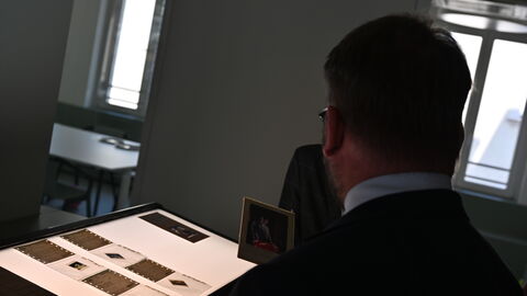 Minister Gremmels schaut sich Fotonegative an.
