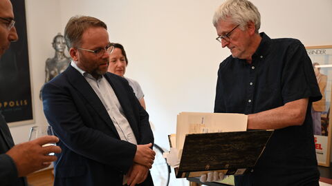 Minister Gremmels schaut sich Requisiten im Fassbinder-Center an.