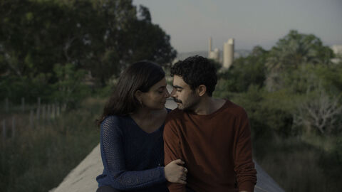 Szene aus "It's a sad and beautiful world": Ein Mann und eine Frau sitzen vertraut beieinander