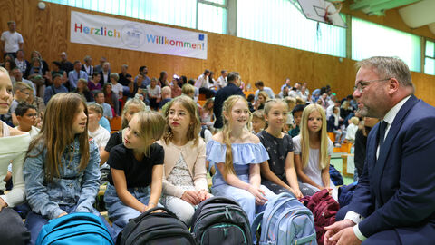 Minister Timon Gremmels spricht mit Schülerinnen und Schülern auf deren Feier zum Schuljahresstart