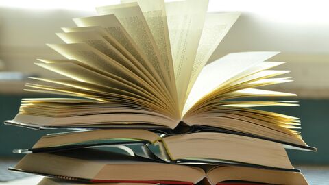 Bücher in Aktion: Das Literaturfestival "Leseland Hessen" hat viel zu bieten Bücher im Gebrauch: Ein Stapel Bücher auf dem ein Buch mit aufgefächerten Seiten liegt