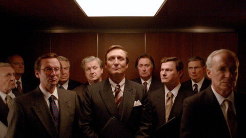 Szene aus "Herrhausen - Herr des Geldes": Menschen stehen im Fahrstuhl