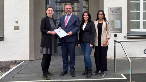 Minister Gremmels überreicht Vertreterinnen von Arbeiterkind.de einen Förderbescheid.