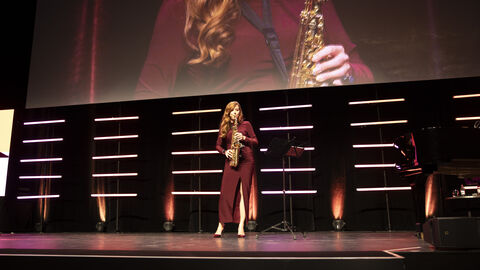 Moderatorin Katrin Bauerfeind spielt Saxophon
