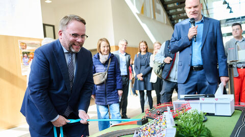 Impressionen vom Tag der offenen Tür am 3. Oktober 2025 in der hessischen Landesvertretung in Berlin. Minister Gremmels lenkt an einem Stand Spielzeugautos.