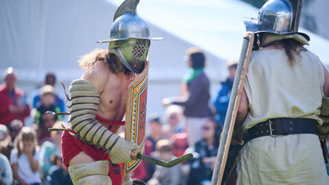 Zwei Männer, verkleidet als römische Gladiatoren, im Kampf