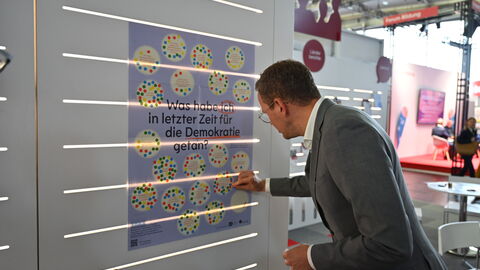Impressionen von der Frankfurter Buchmesse 2025. Christoph Degen markiert etwas auf einer Karte
