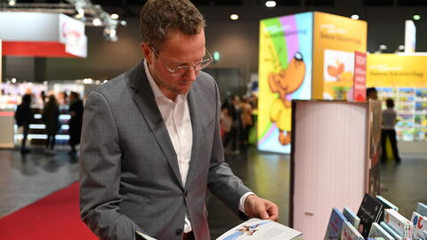 Impressionen von der Frankfurter Buchmesse 2025. Christoph Degen schaut sich ein Buch an