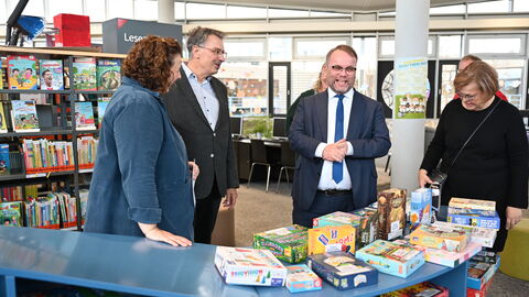 Minister Gremmels schaut sich Spiele an und lacht.