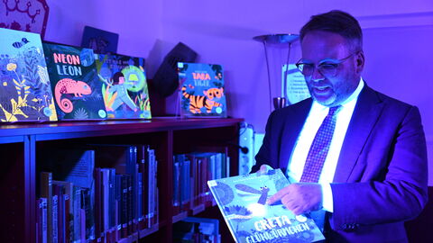 Minister Gremmels schaut sich ein fluoizierendes Buch an.