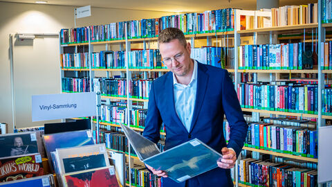 Staatssekretär Christoph Degen schaut sich ein Bilderbuch an.