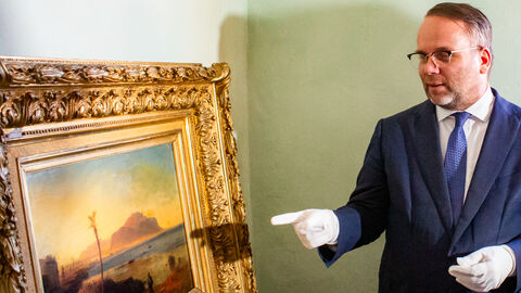 Minister Gremmels schaut sich ein Gemälde an.