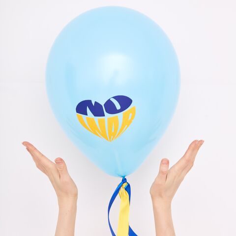 Zwei Hände halten einen Luftballon, auf dem "no war" (kein Krieg) in den ukrainischen Farben steht