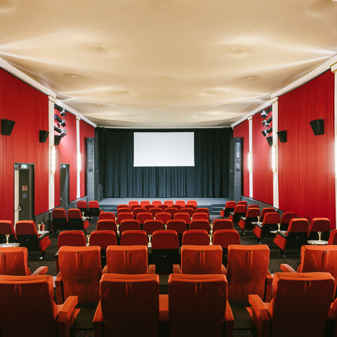 Die FilmBühne Nauheim ist eine von drei Veranstaltungsstätten für den Hessische Film- und Kinopreis 2022. Blick in den Kinosaal der FilmBühne Nauheim über die Kinosessel hinweg auf die Leinwand