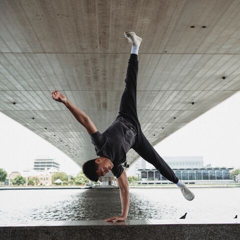 Ein Breakdancer tantzt unter einer Brücke