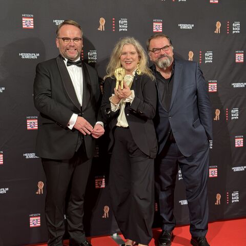 Der Ehrenpreis des Hessischen Ministerpräsidenten geht an die international renommierte Schauspielerin Barbara Sukowa Minister Gremmels und Barbara Sukowa vor einer Fotoleinwand.